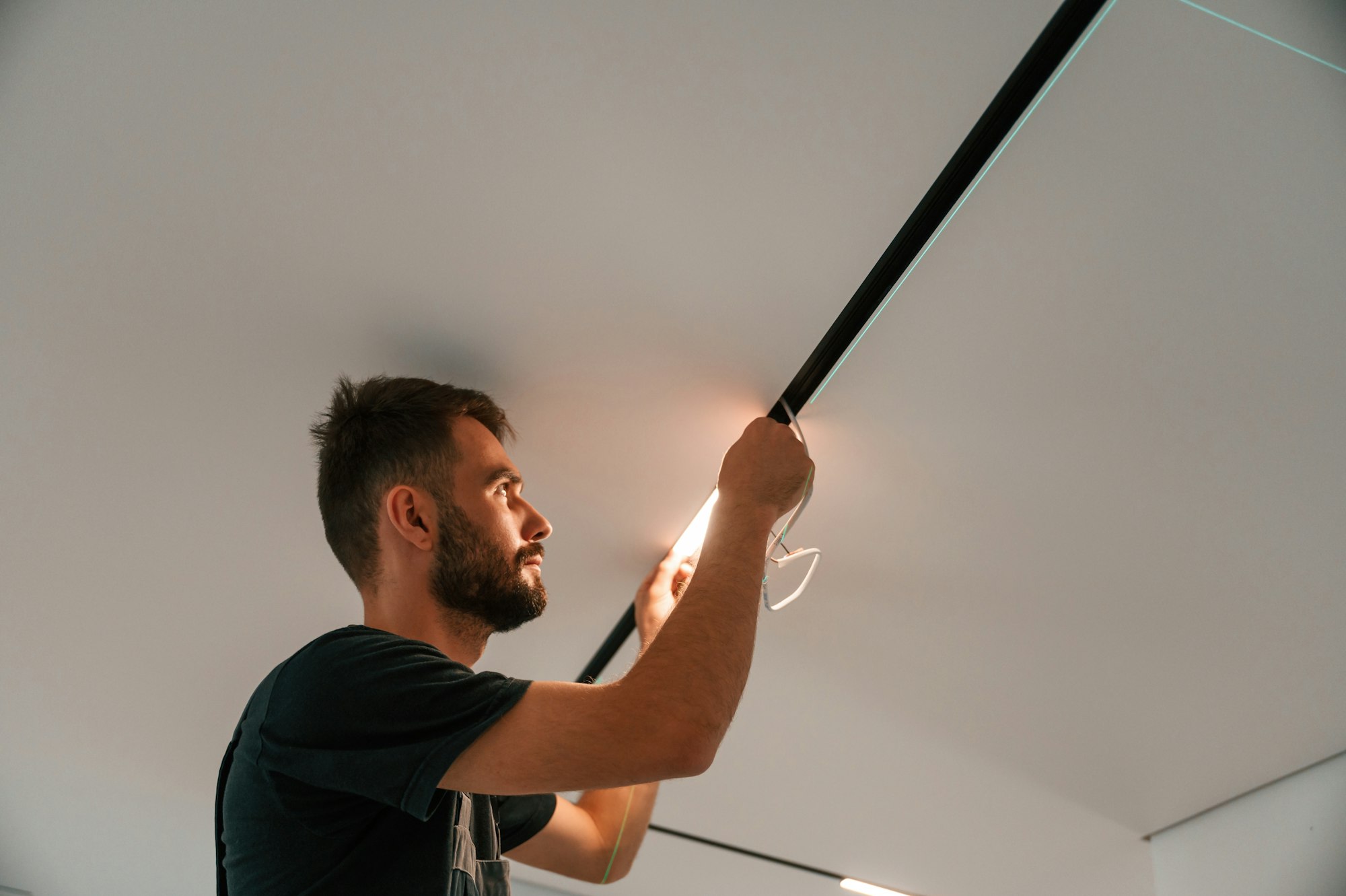 Man is working with lighting equipment indoors at domestic room