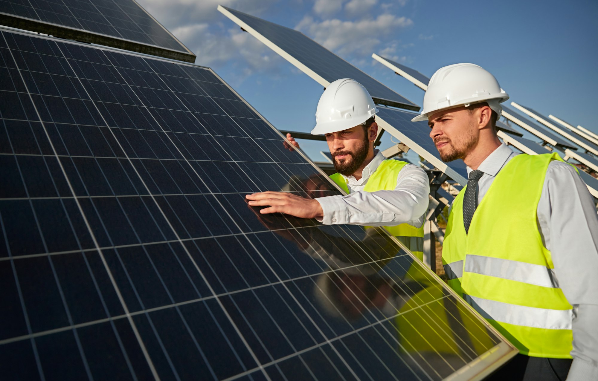 Technicians examining solar panels installation